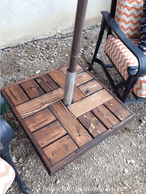 diy wood patio table top shown with umbrella stand on patio