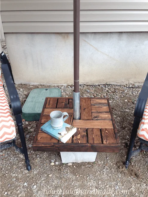  umbrella stand with a DIY patio side table with a book and a cup of coffee