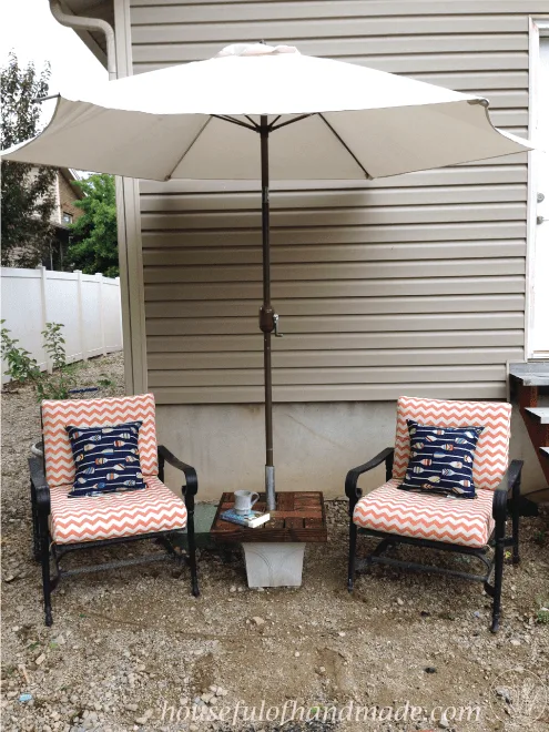DIY umbrella stand with a side table with two patio chairs and white umbrella