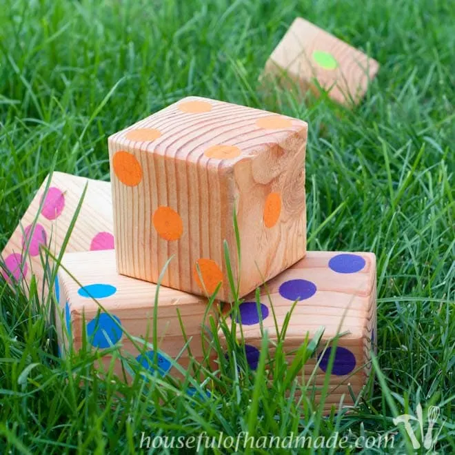 Set of 6 rainbow colored DIY yard dice made from 4x4s and craft paint.