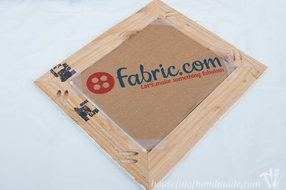 back of diy rustic picture frame showing fabric.com cardboard taped to it