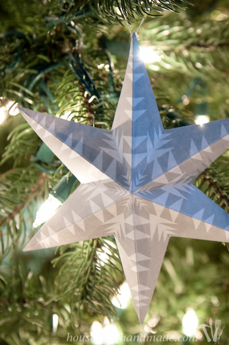 Gray 3D star with snowflake design on a paper Christmas ornament. 