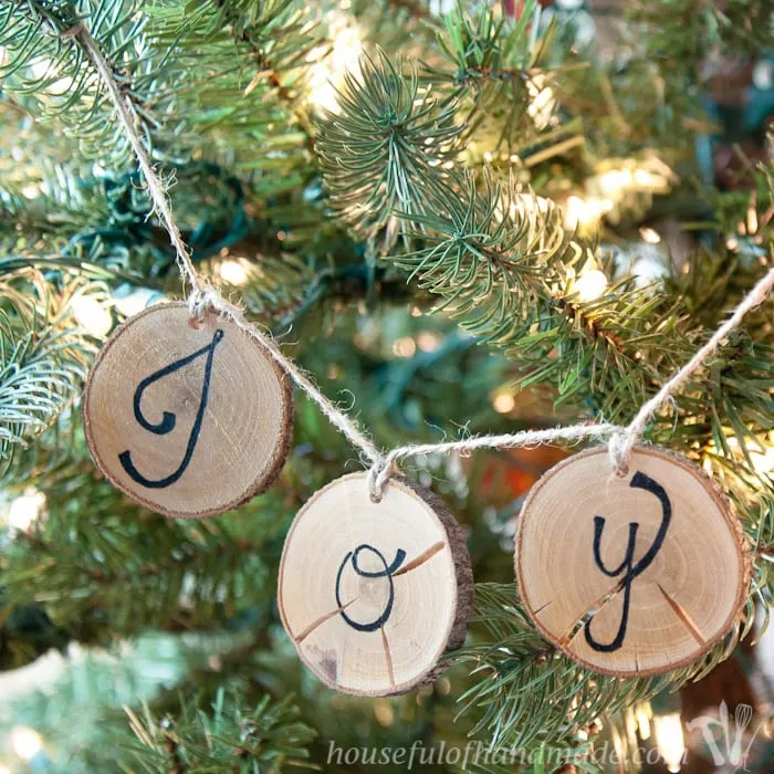 I love wood slice ornaments. Help them make a statement on your tree with these easy wood slice ornament banners. Beautiful and rustic. | Housefulofhandmade.com