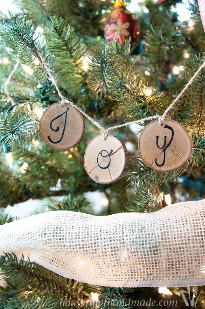 I love wood slice ornaments. Help them make a statement on your tree with these easy wood slice ornament banners. Beautiful and rustic. | Housefulofhandmade.com