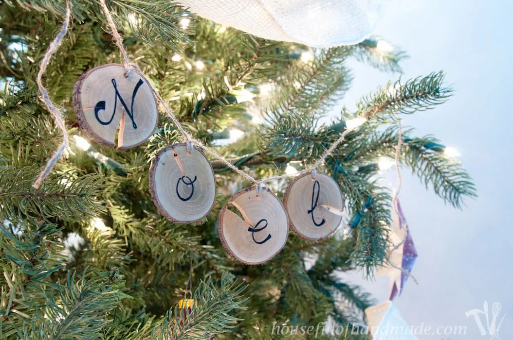 I love wood slice ornaments. Help them make a statement on your tree with these easy wood slice ornament banners. Beautiful and rustic. | Housefulofhandmade.com