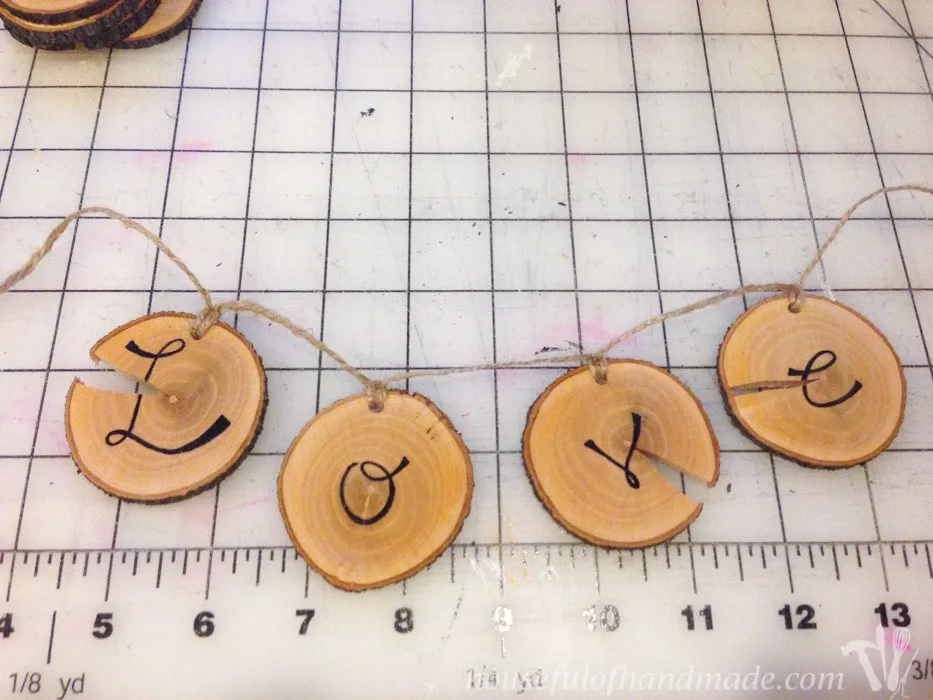 I love wood slice ornaments. Help them make a statement on your tree with these easy wood slice ornament banners. Beautiful and rustic. | Housefulofhandmade.com