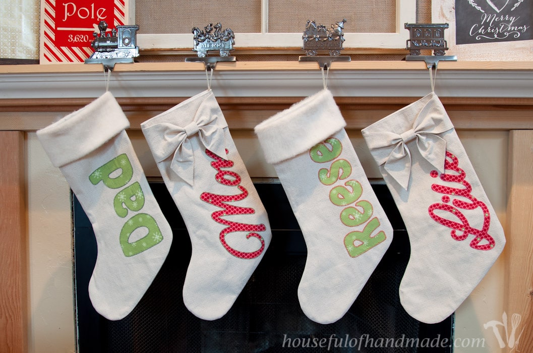 Set of 4 personalized Christmas stockings hanging on mantel.