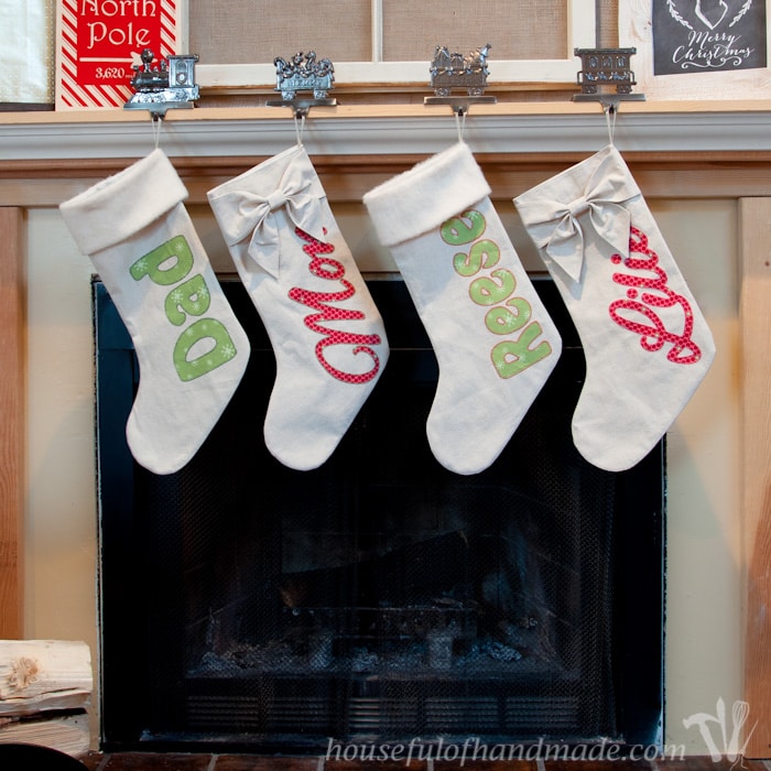 DIY personalized drop cloth Christmas stockings shown hanging on mantel.