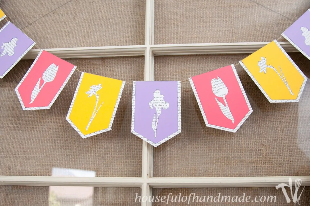 I love using banners to decorate. Create a beautiful spring flower & book page banner with this tutorial and free digital cut file. | Housefulofhandmade.com