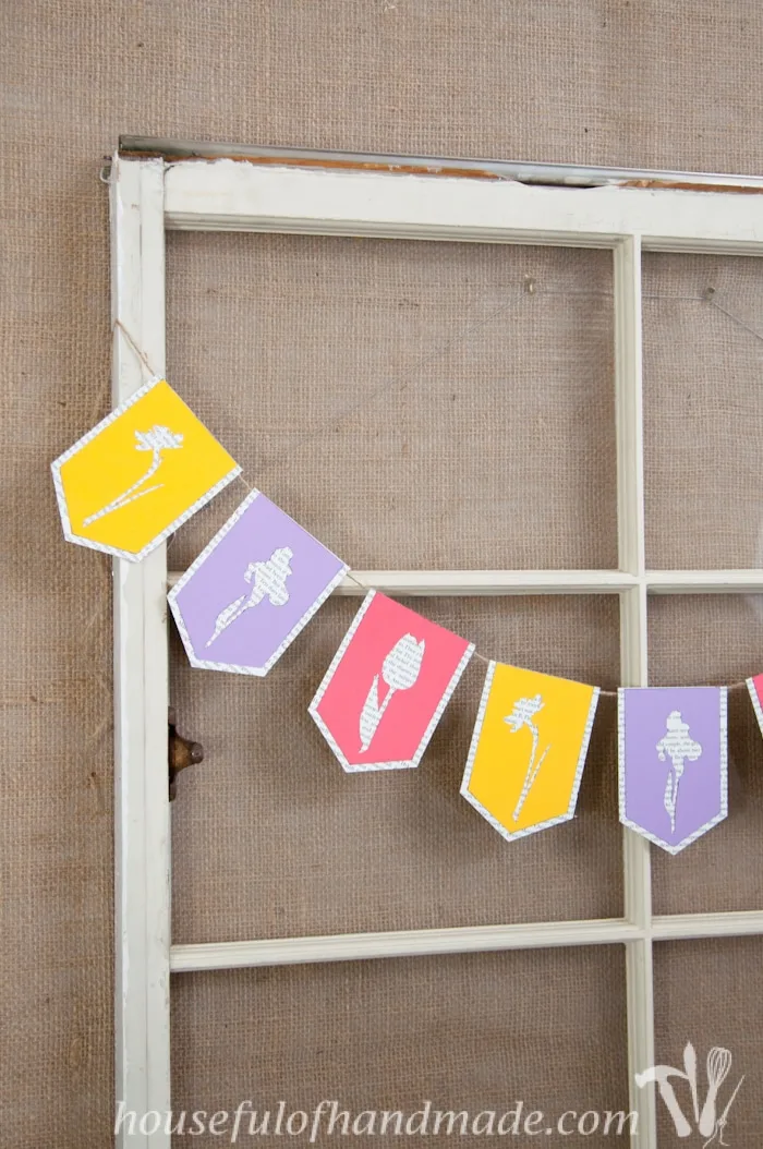 I love using banners to decorate. Create a beautiful spring flower & book page banner with this tutorial and free digital cut file. | Housefulofhandmade.com