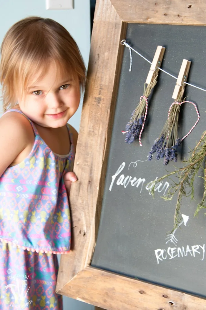 Make drying your herbs a part of your decor with this DIY rustic chalkboard herb drying rack. It's made from an old pallet and makes preserving herbs beautiful. | Housefulofhandmade.com