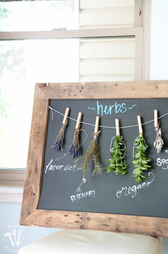 Make drying your herbs a part of your decor with this DIY rustic chalkboard herb drying rack. It's made from an old pallet and makes preserving herbs beautiful. | Housefulofhandmade.com