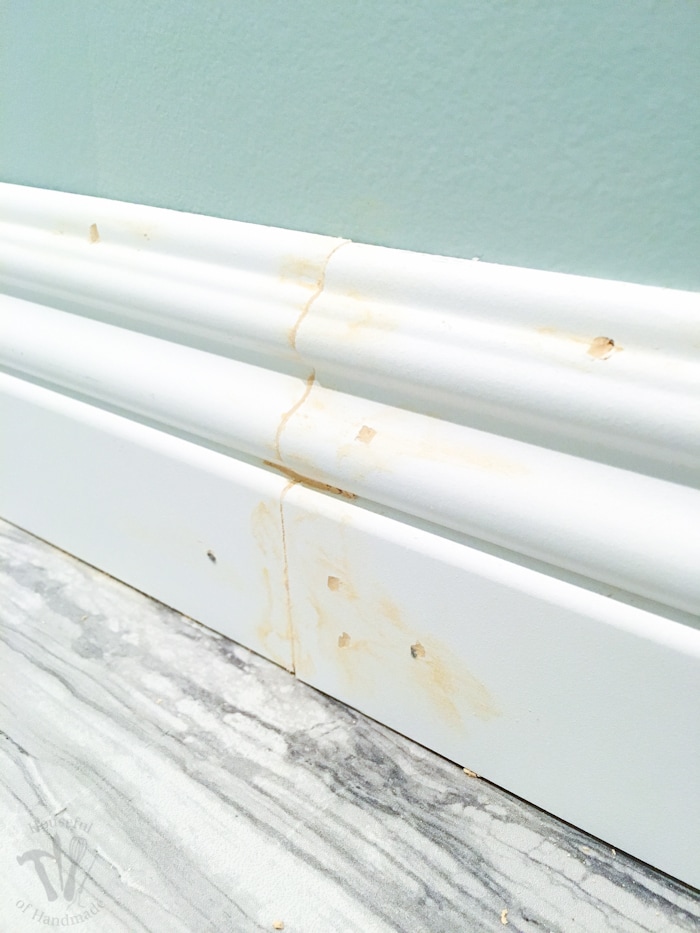This week we installed baseboards into the master bathroom. While I continue to struggle with installing baseboards and door trim, I am really great at filling in any gaps with this cheater trick! | Housefulofhandmade.com