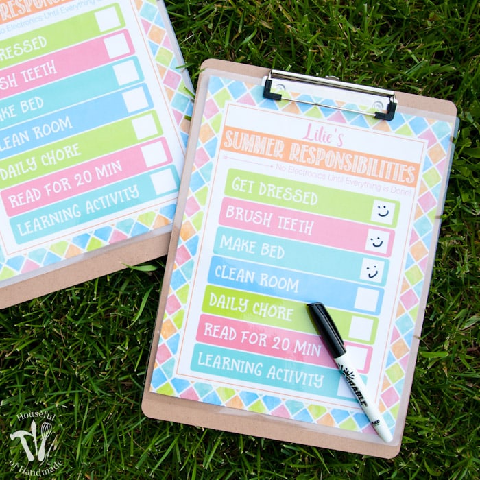 clipboard and pen with free printable summer chore chart on grass