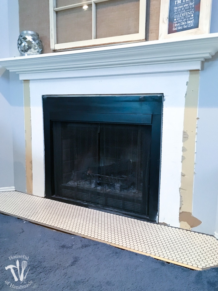 I'm working on updating a boring fireplace with a farmhouse style starting with tiling the fireplace hearth. The fireplace will be surrounded with beautiful white hexagon tiles with a gray grout. A wonderful update for only $100. | Housefulofhandmade.com