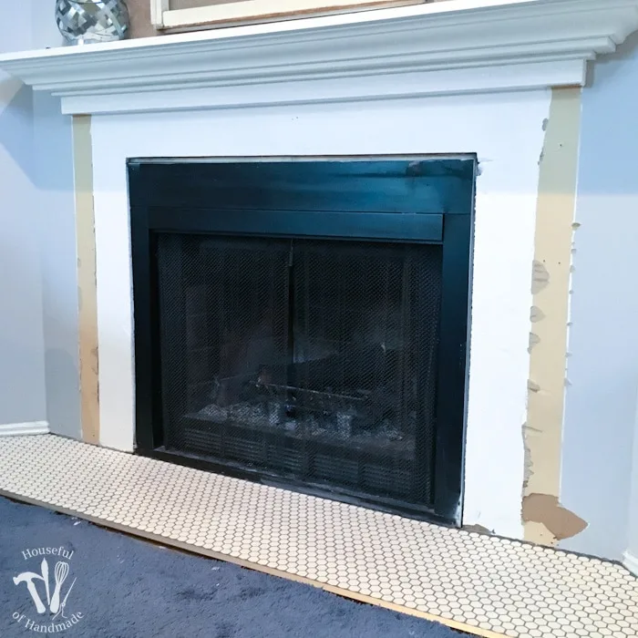 I'm working on updating a boring fireplace with a farmhouse style starting with tiling the fireplace hearth. The fireplace will be surrounded with beautiful white hexagon tiles with a gray grout. A wonderful update for only $100. | Housefulofhandmade.com