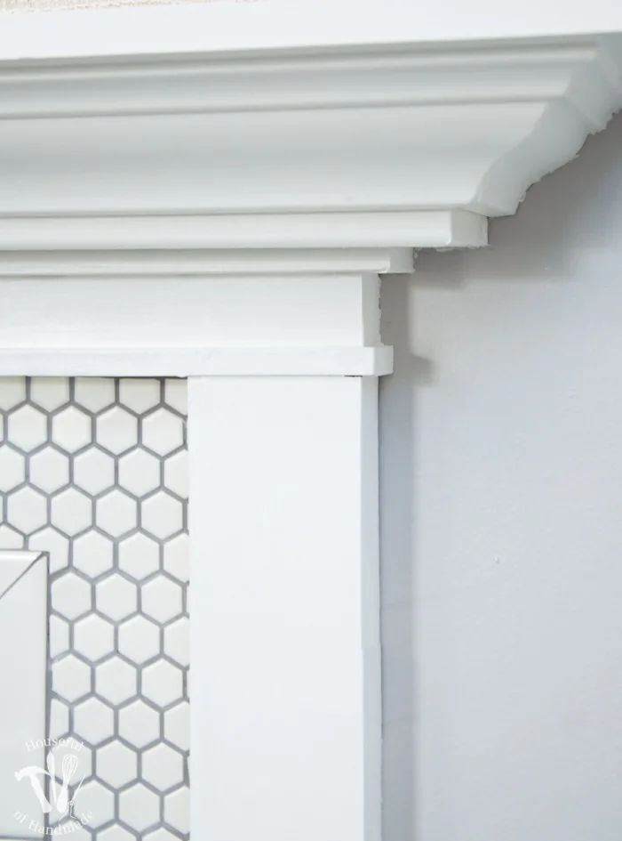 I love this vintage inspired farmhouse fireplace. DIY your own fireplace with new white hexagon tile on a budget. Love the white tiles and gray grout. Farmhouse fireplace reveal from Housefulofhandmade.com