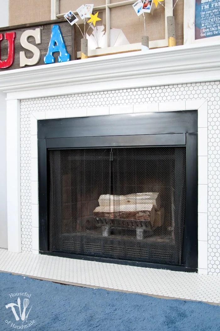 I love this vintage inspired farmhouse fireplace. DIY your own fireplace with new white hexagon tile on a budget. Love the white tiles and gray grout. Farmhouse fireplace reveal from Housefulofhandmade.com