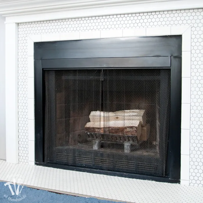 I love this vintage inspired farmhouse fireplace. DIY your own fireplace with new white hexagon tile on a budget. Love the white tiles and gray grout. Farmhouse fireplace reveal from Housefulofhandmade.com