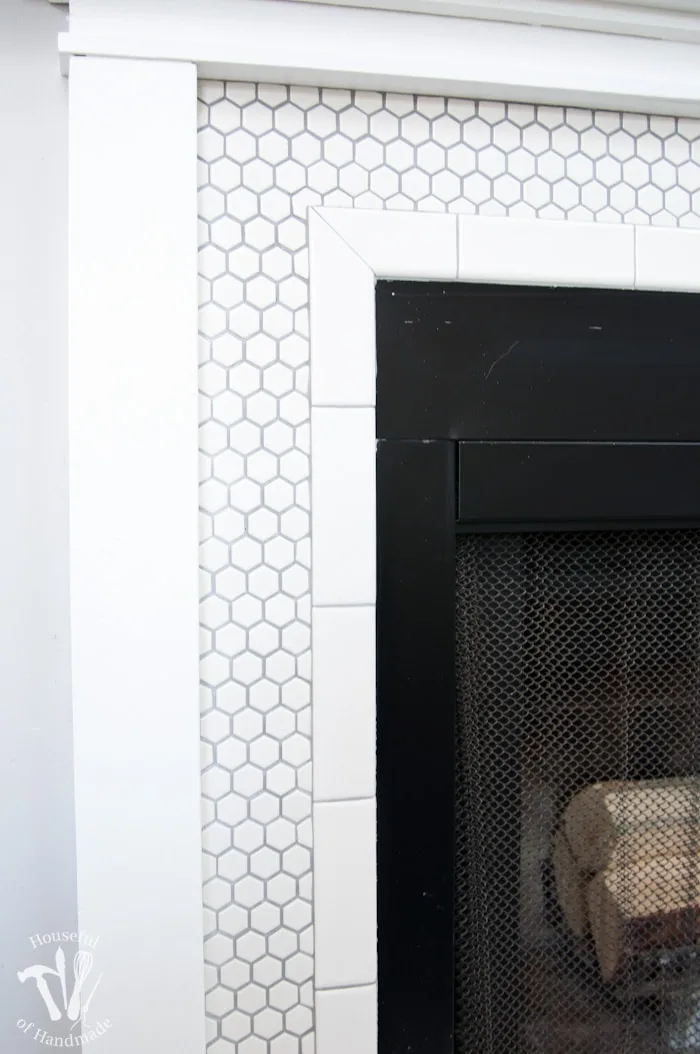 I love this vintage inspired farmhouse fireplace. DIY your own fireplace with new white hexagon tile on a budget. Love the white tiles and gray grout. Farmhouse fireplace reveal from Housefulofhandmade.com