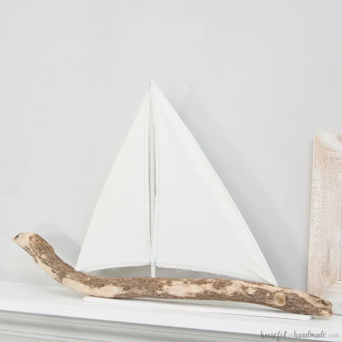 I love coastal decor! If you've ever skipped making your favorite driftwood project because you don't live by the ocean, no need for that anymore. Check out the tutorial for this DIY driftwood sailboat decor and find out where she found driftwood in a land locked state. | Housefulofhandmade.com