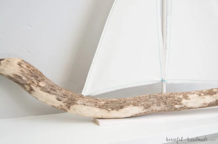 I love coastal decor! If you've ever skipped making your favorite driftwood project because you don't live by the ocean, no need for that anymore. Check out the tutorial for this DIY driftwood sailboat decor and find out where she found driftwood in a land locked state. | Housefulofhandmade.com