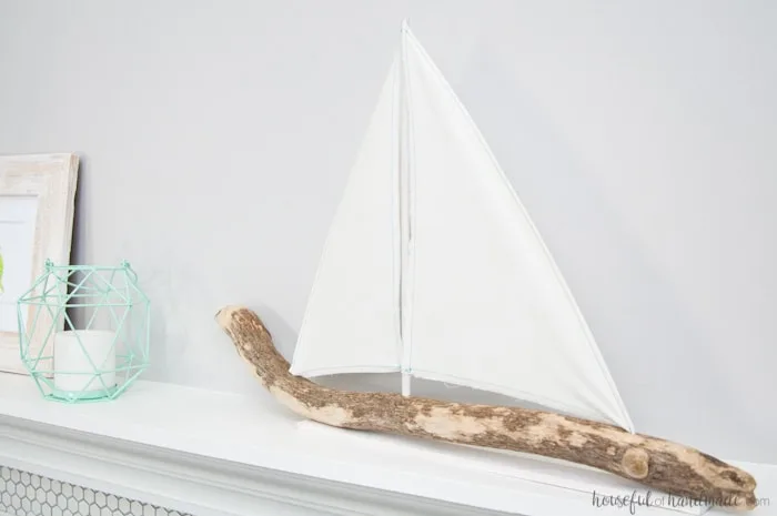 I love coastal decor! If you've ever skipped making your favorite driftwood project because you don't live by the ocean, no need for that anymore. Check out the tutorial for this DIY driftwood sailboat decor and find out where she found driftwood in a land locked state. | Housefulofhandmade.com