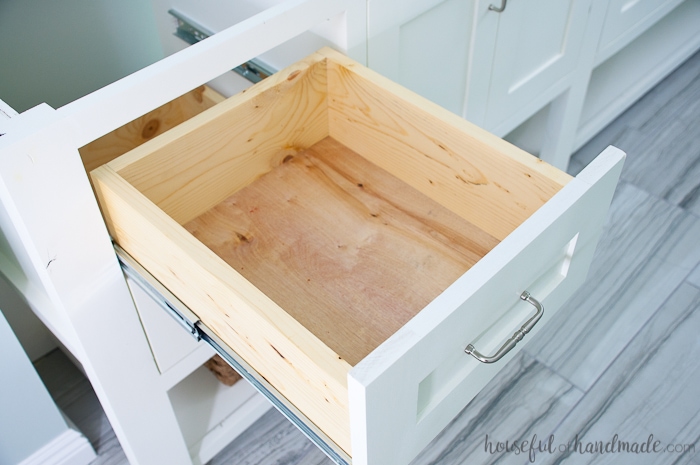 Large drawer in a bathroom vanity pulled open showing the the drawer box. 