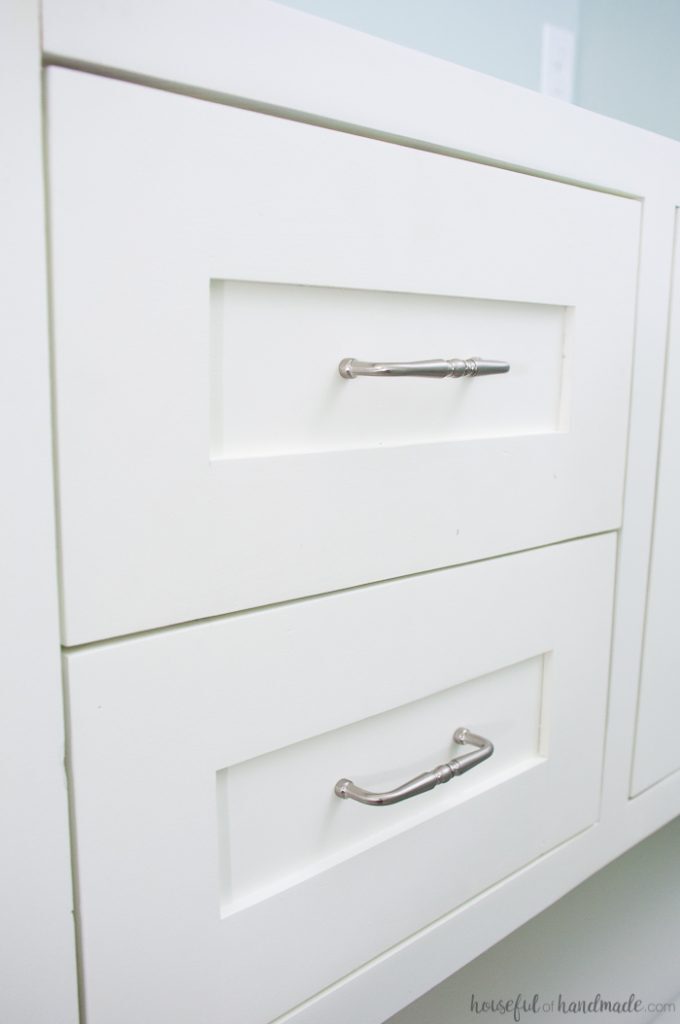 Inset shaker doors on a bathroom vanity with silver pulls in the center panel. 