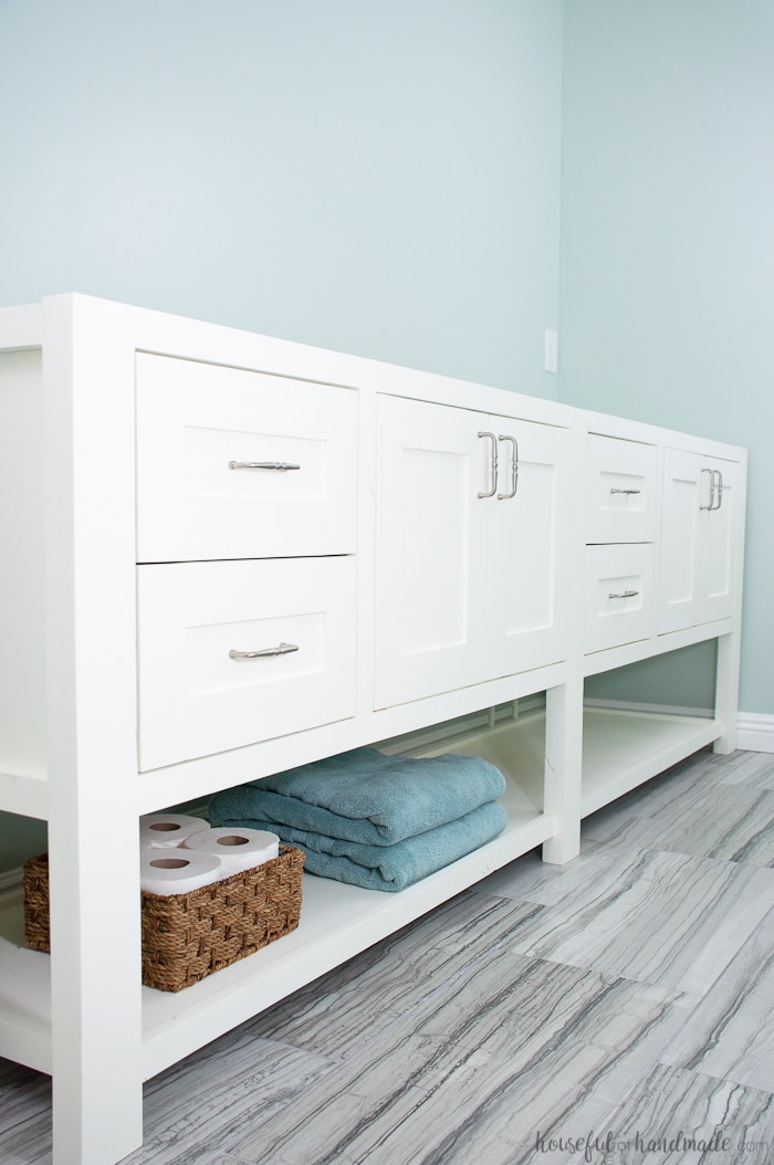 Large double vanity with open shelf on bottom painted white. 