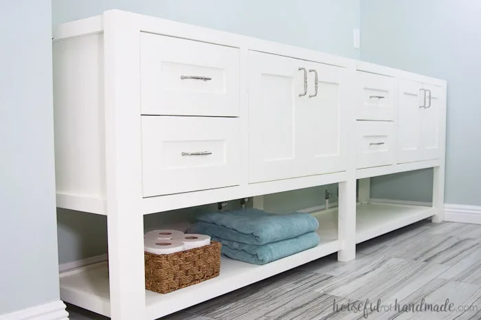 Furniture style bathroom vanity, with an open shelf on the bottom, painted white. 