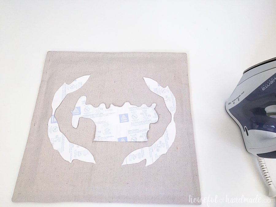 Printable transfer cut out on a decorative pillow before ironing.