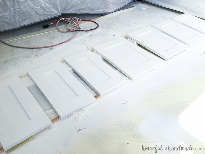 Cabinet doors and drawer fronts for the master bathroom vanity being painted with a paint sprayer to get a smooth paint finish. 