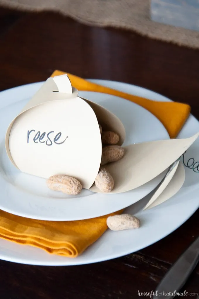 Make Thanksgiving extra festive with these easy Thanksgiving place cards that can be filled with treats for an easy appetizer. These paper pumpkin boxes are easy to make and will leave your guests feeling extra special this holiday season. | Housefulofhandmade.com