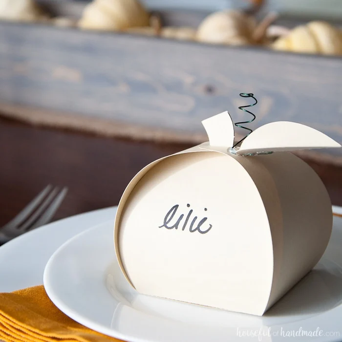 Make Thanksgiving extra festive with these easy Thanksgiving place cards that can be filled with treats for an easy appetizer. These paper pumpkin boxes are easy to make and will leave your guests feeling extra special this holiday season. | Housefulofhandmade.com