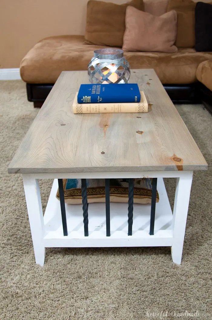 Farmhouse coffee table with iron accents and a weathered gray natural stain on the top. 