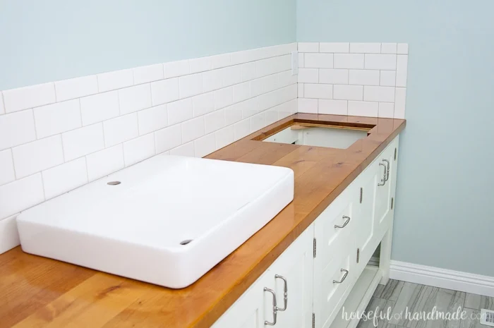 Bathroom vanity with DIY wood top and vessel sinks. 