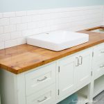 White mission style DIY bathroom vanity with wood vanity top and square vessel sinks.