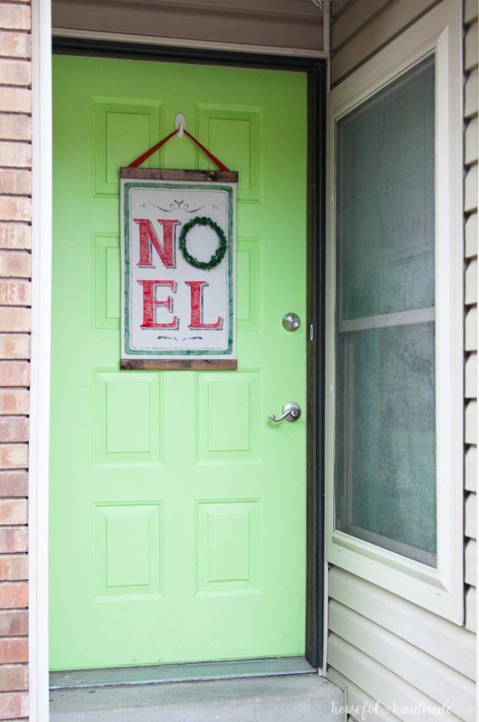 full view of green front door with vintage noel scroll