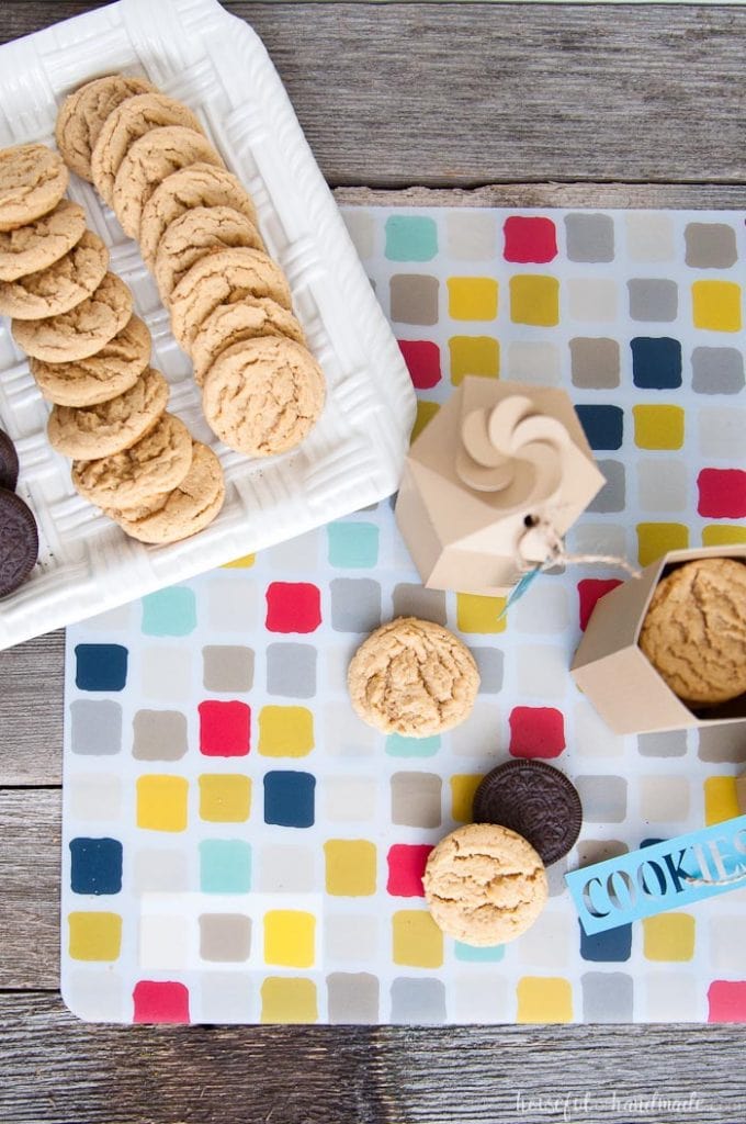 over head view of two printable cookie boxes, one open, next to a tray of cookies