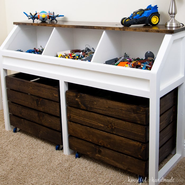 I love this grown-up take on a toy box! Create a console table to organize all the toys. This rustic toy storage unit has large open bins and rolling carts for lots of toy storage. Get the free build plans. | Housefulofhandmade.com