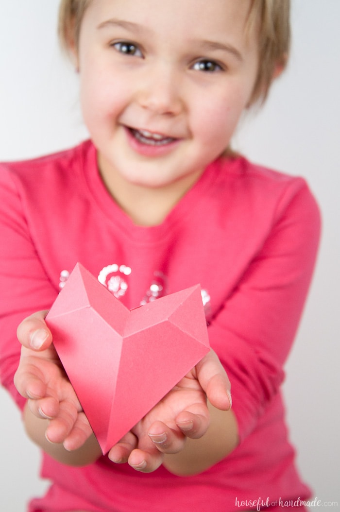 little girl holding a 3d pink heart valentne