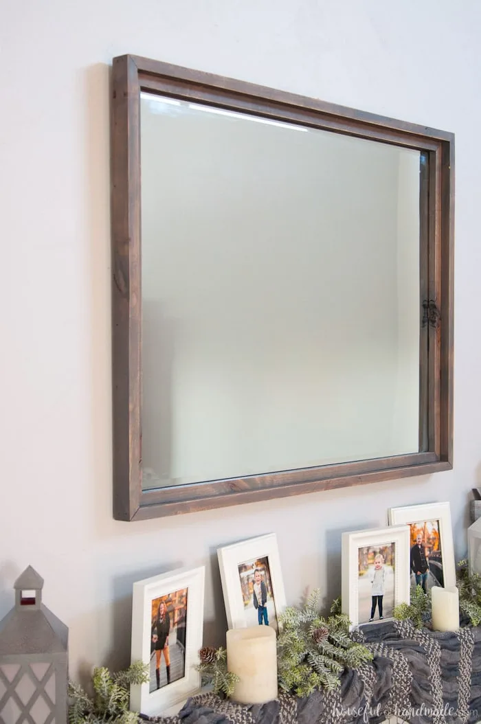 Gray stained frame around large beveled mirror over mantel. 