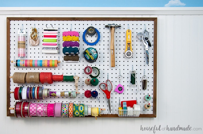 Create the perfect place to organize your most used supplies! Learn how to hang pegboard so it is removable if needed. Housefulofhandmade.com | Craft organization ideas | Craft room remodel | Pegboard organization | $100 Room Challenge | Easy woodworking | Easy building plans | Free Building plans 