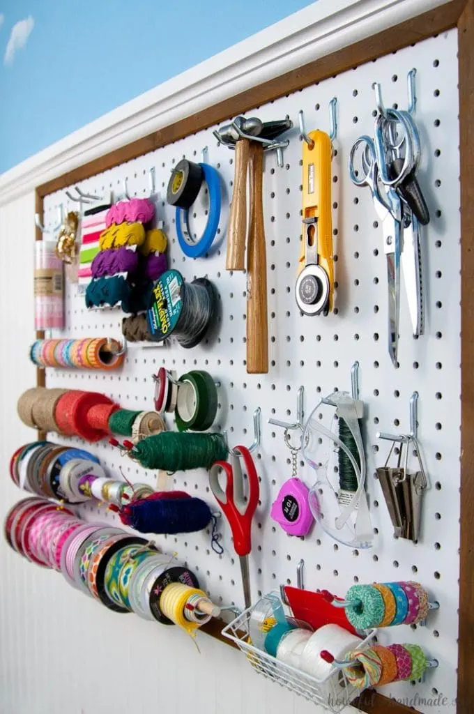 Create the perfect place to organize your most used supplies! Learn how to hang pegboard so it is removable if needed. Housefulofhandmade.com | Craft organization ideas | Craft room remodel | Pegboard organization | $100 Room Challenge | Easy woodworking | Easy building plans | Free Building plans 