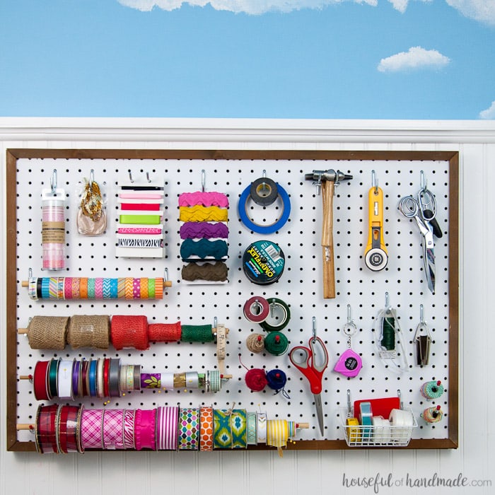 Create the perfect place to organize your most used supplies! Learn how to hang pegboard so it is removable if needed. Housefulofhandmade.com | Craft organization ideas | Craft room remodel | Pegboard organization | $100 Room Challenge | Easy woodworking | Easy building plans | Free Building plans