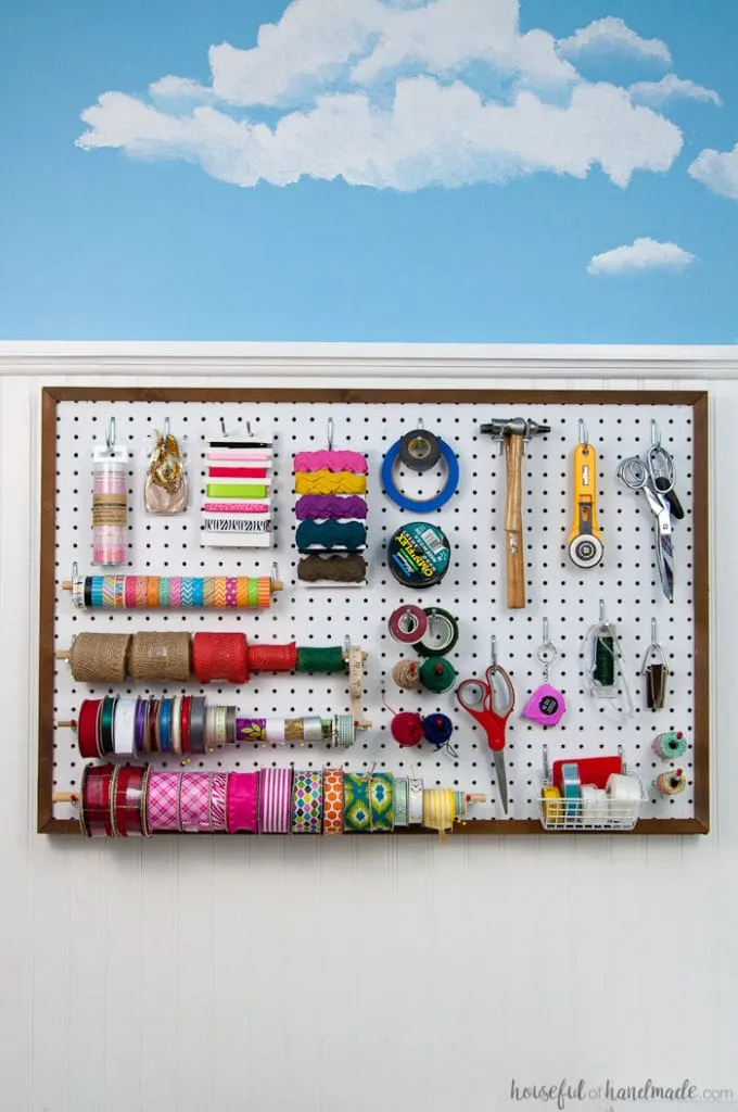 Create the perfect place to organize your most used supplies! Learn how to hang pegboard so it is removable if needed. Housefulofhandmade.com | Craft organization ideas | Craft room remodel | Pegboard organization | $100 Room Challenge | Easy woodworking | Easy building plans | Free Building plans 