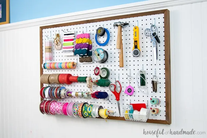 Use these amazing DIYs to Organize your home this year. Create the perfect place to organize your most used supplies! Learn how to hang pegboard so it is removable if needed. Housefulofhandmade.com | Craft organization ideas | Craft room remodel | Pegboard organization | $100 Room Challenge | Easy woodworking | Easy building plans | Free Building plans