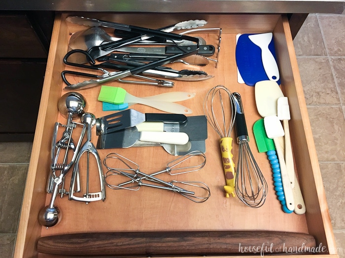 kitchen drawer with a rough lay out of utensils prior to organizer being installed