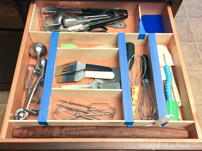 kitchen drawer organizer with tape holding it together while the glue dries.